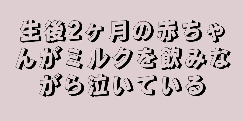生後2ヶ月の赤ちゃんがミルクを飲みながら泣いている