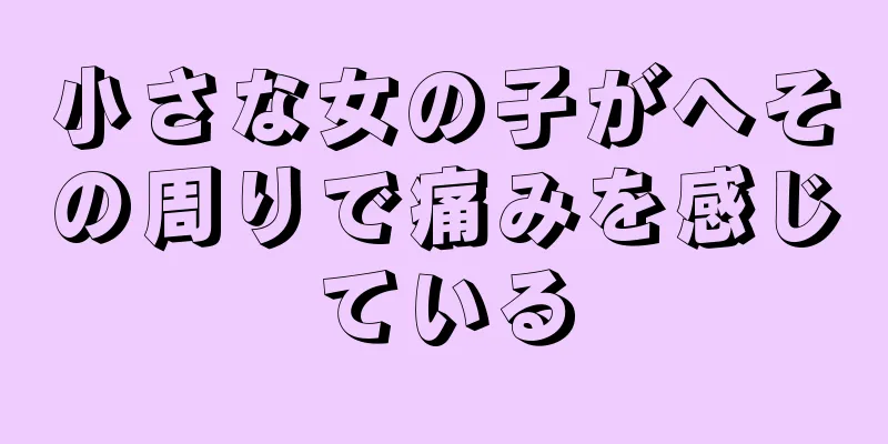 小さな女の子がへその周りで痛みを感じている