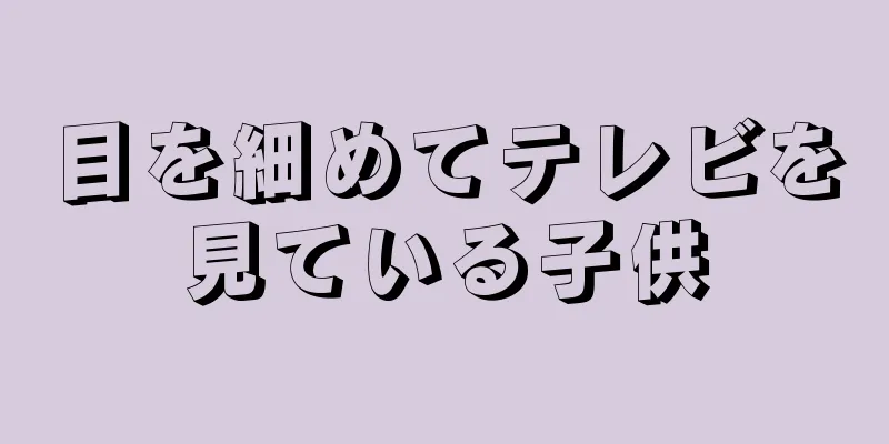 目を細めてテレビを見ている子供