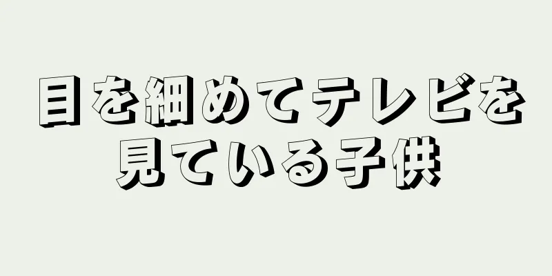 目を細めてテレビを見ている子供